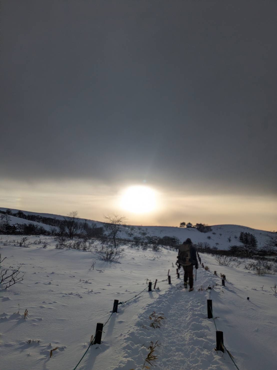 雪原の登山道と夕日。出張帰りの静かな山。